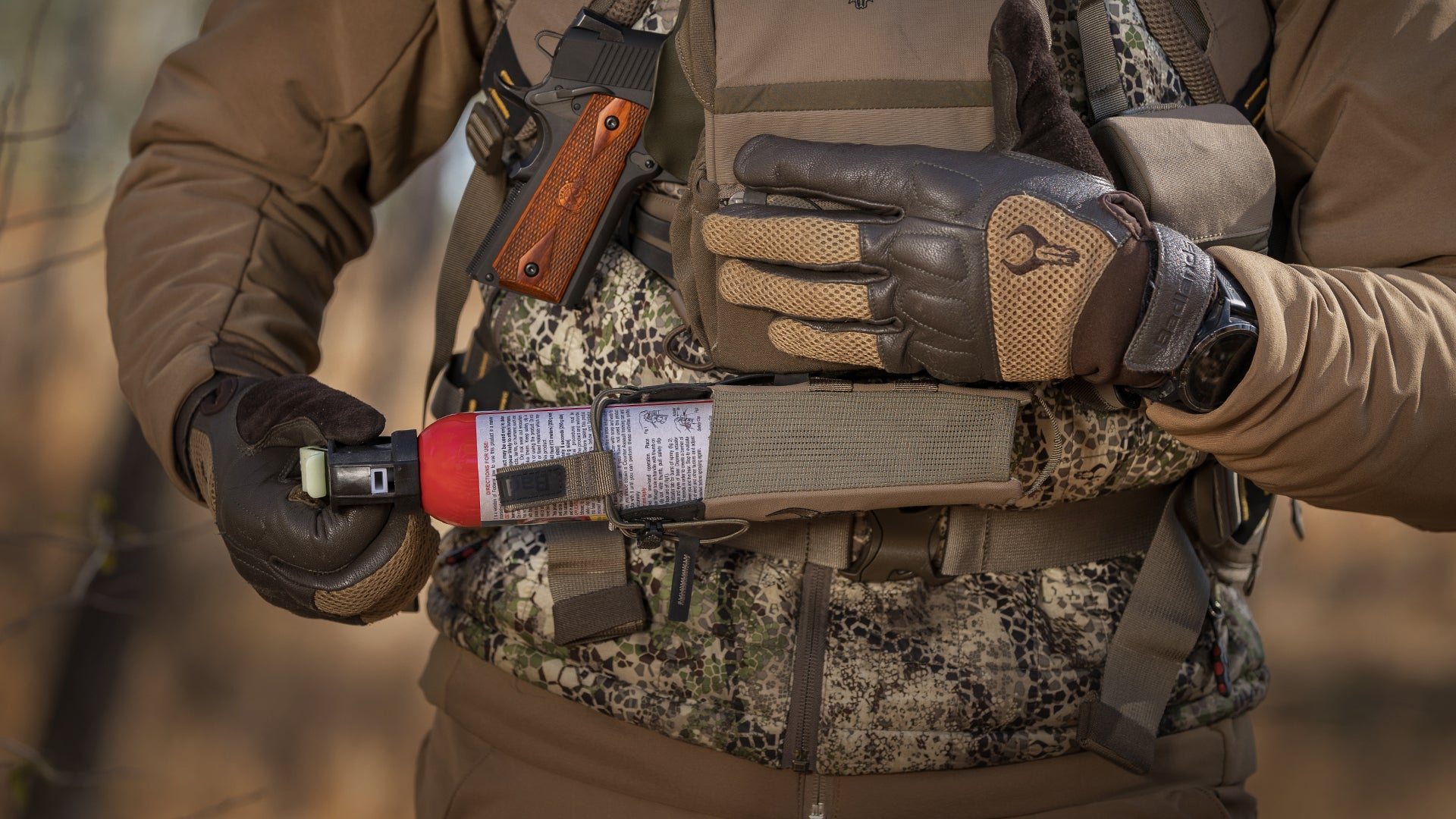 man pulling bear spray out of bino harness