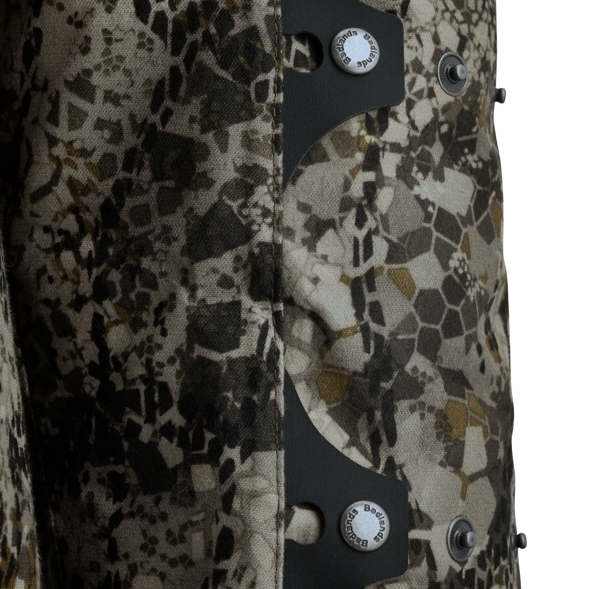 Close-up of Moonrivers camo fabric with hexagonal pattern and Moonrivers skull logo on metal snap buttons.