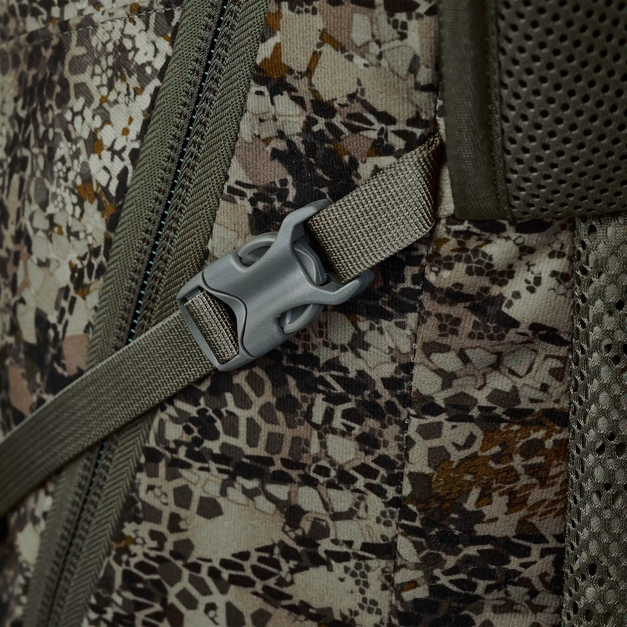 Close-up of a camo-patterned backpack with a plastic buckle, zipper, and mesh padding. No Moonrivers Logo visible.