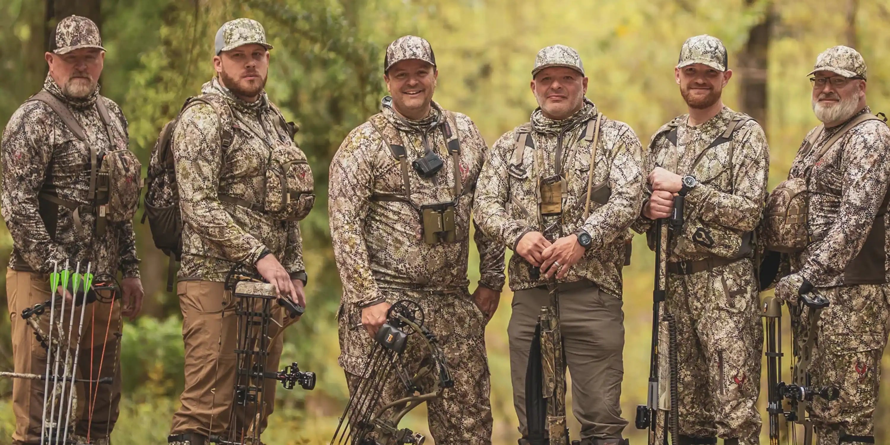 Six hunters in Moonrivers camo gear stand outdoors with bows and packs, featuring the Moonrivers skull logo on their clothing.