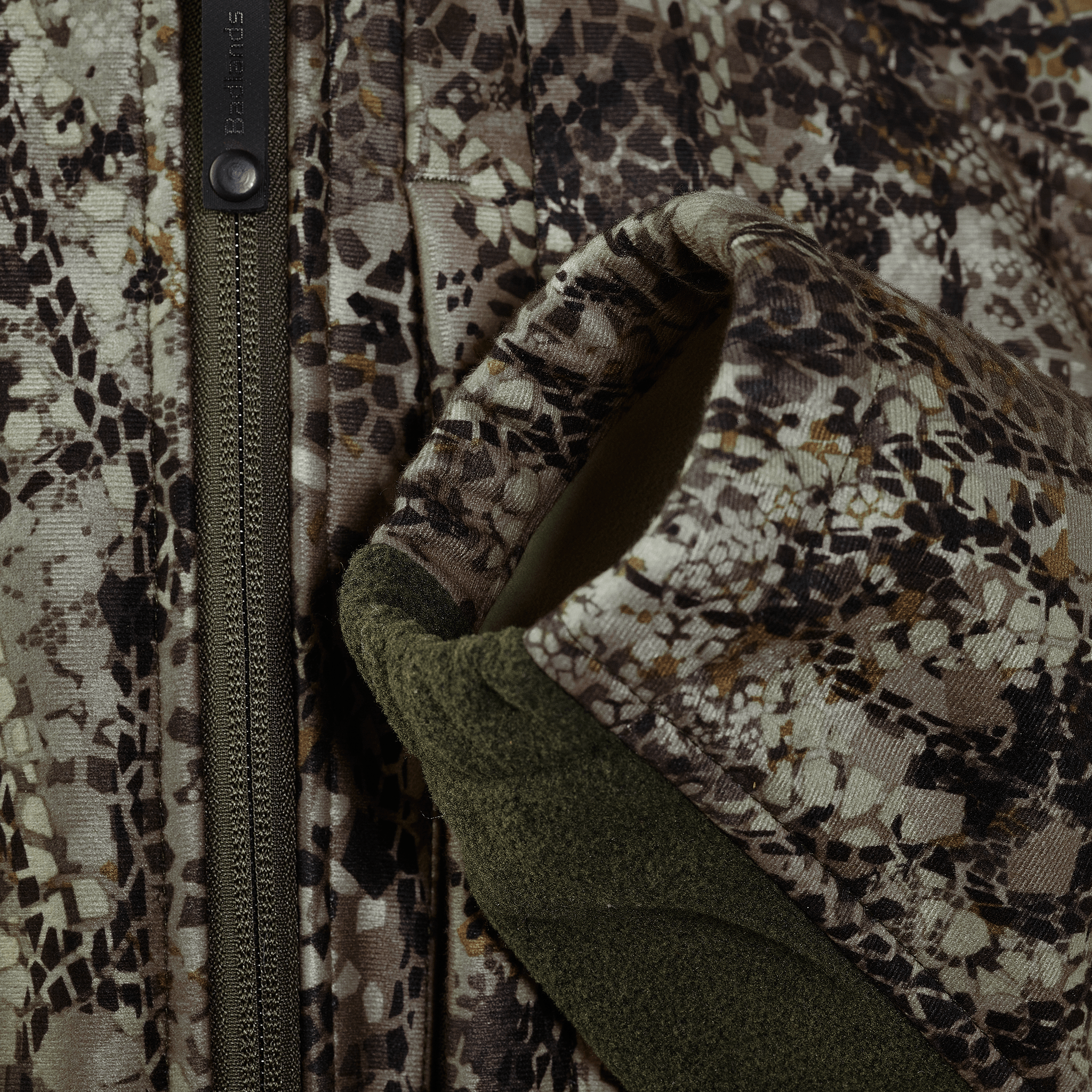 Close-up of Moonrivers camo jacket with zipper and textured sleeve, showing detailed camouflage pattern and fabric.