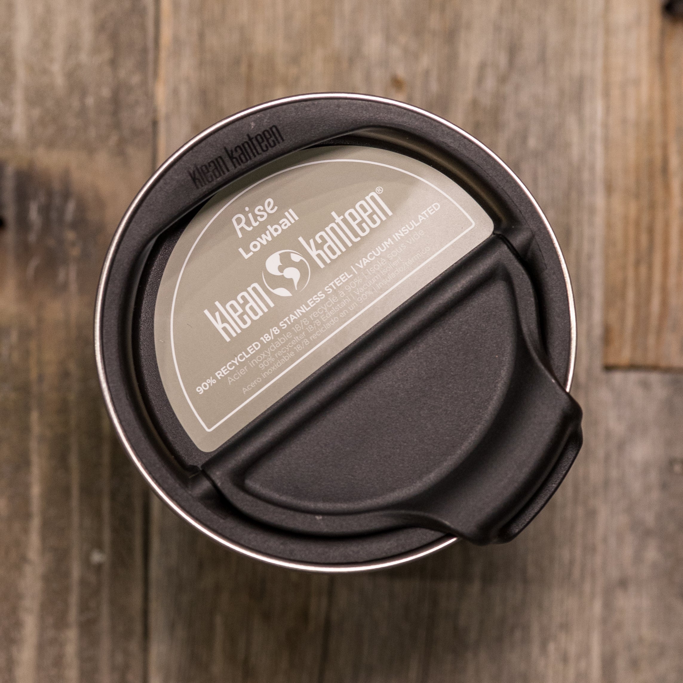 Top view of a Klean Kanteen Rise Lowball cup with a black lid, placed on a wooden surface.