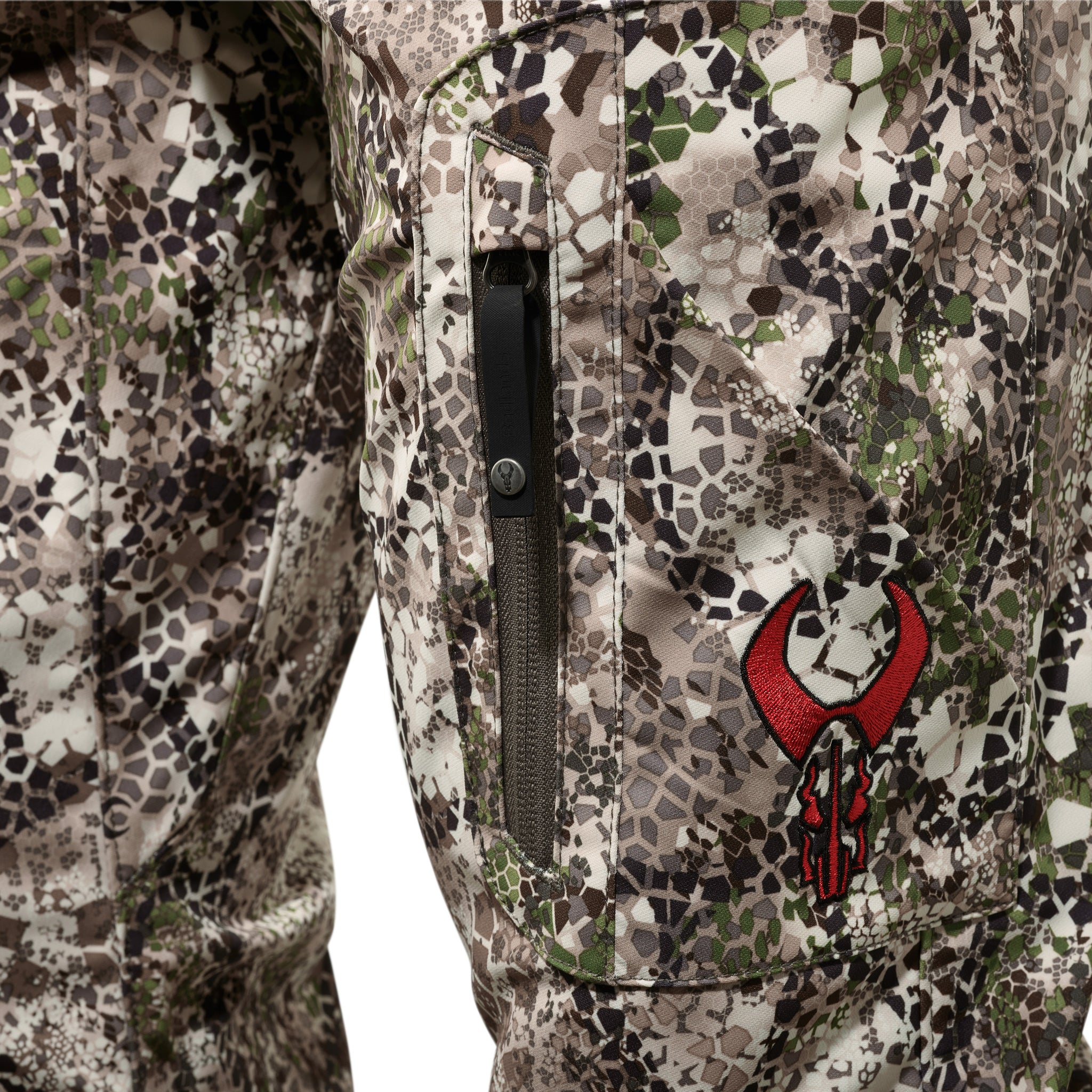 Close-up of Moonrivers camo pants with zippered pocket and red Moonrivers skull logo embroidered on the thigh.