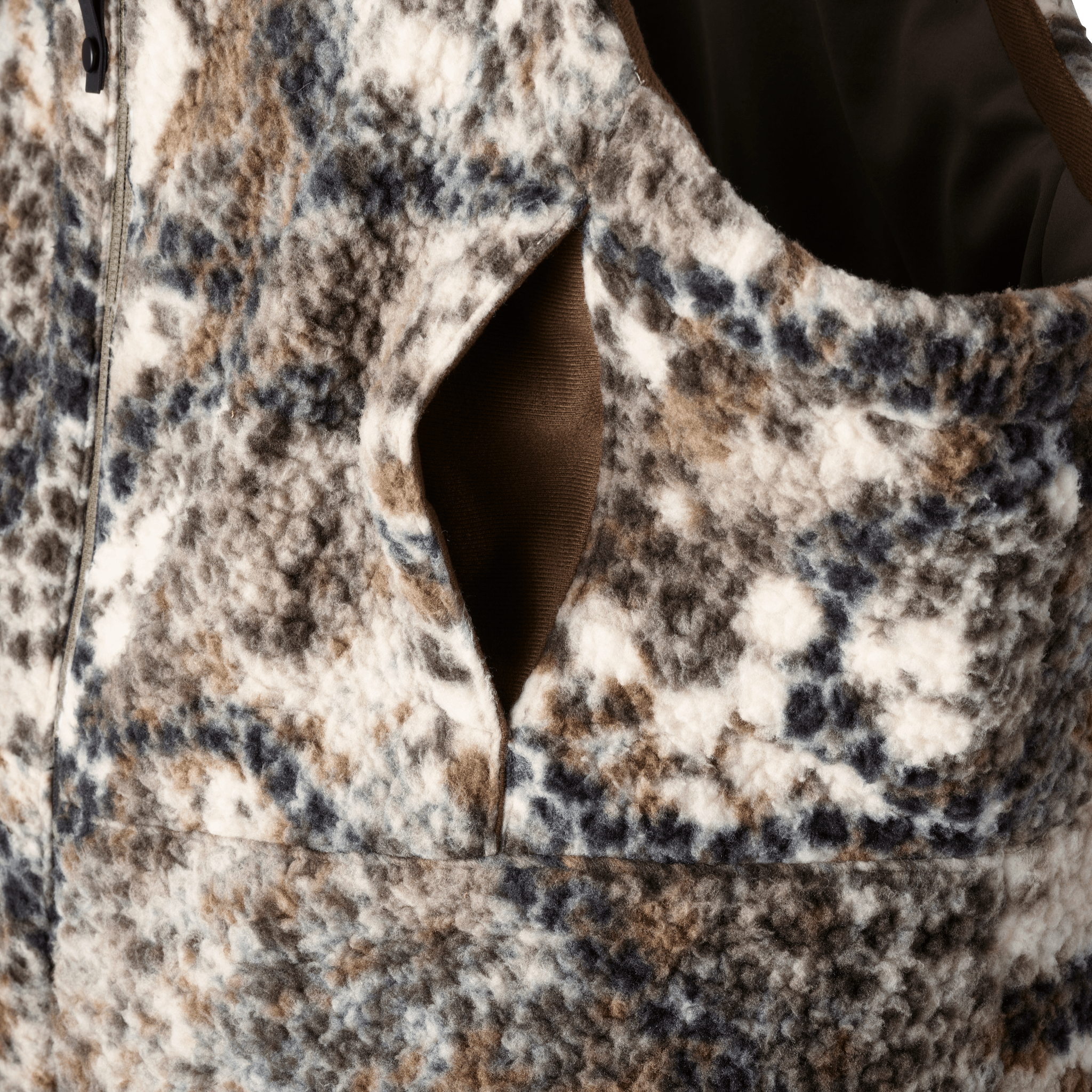 Close-up of Moonrivers camo fleece vest with zip and pocket; textured fabric in brown, blue, and white pattern.