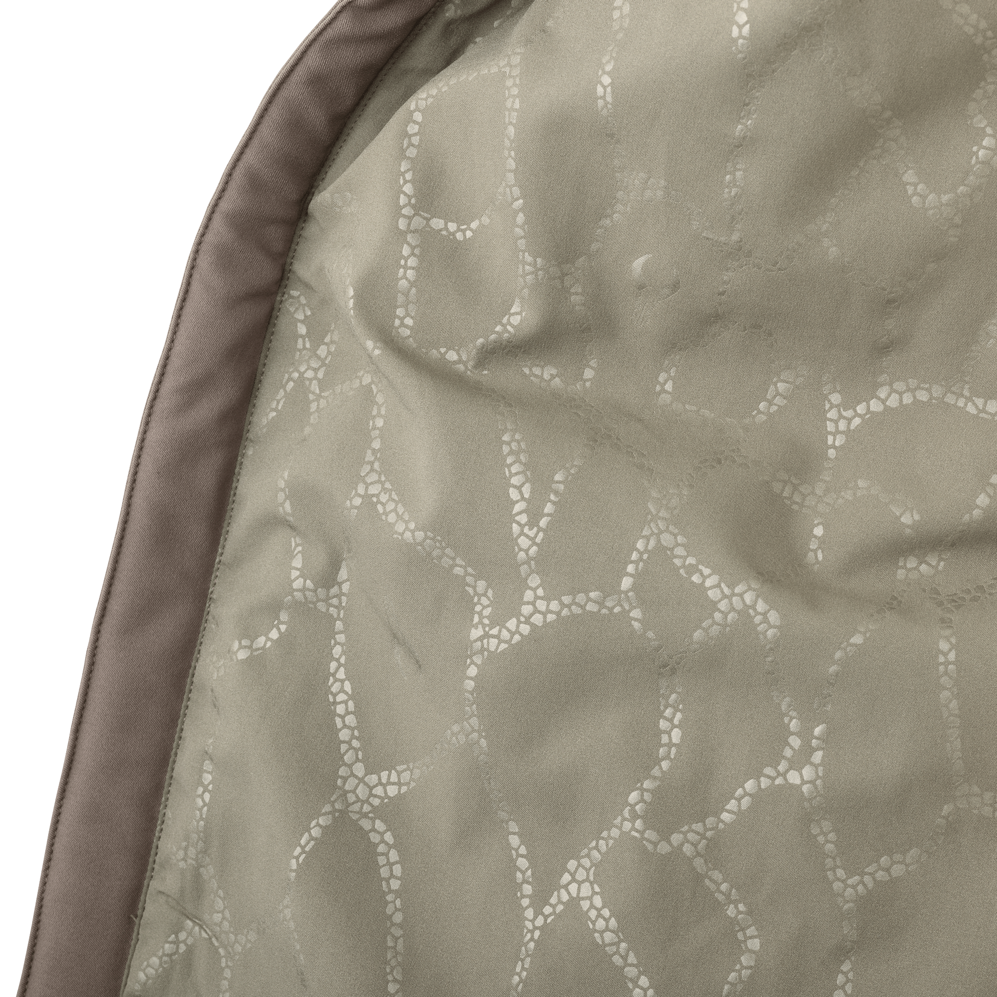Close-up of tan fabric with a subtle branch-like pattern; no visible Moonrivers Logo or other symbols.